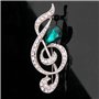 Broche Belons tendance en forme de note de musique/clé de sol avec strass et cristal vert en forme de goutte, pour femme